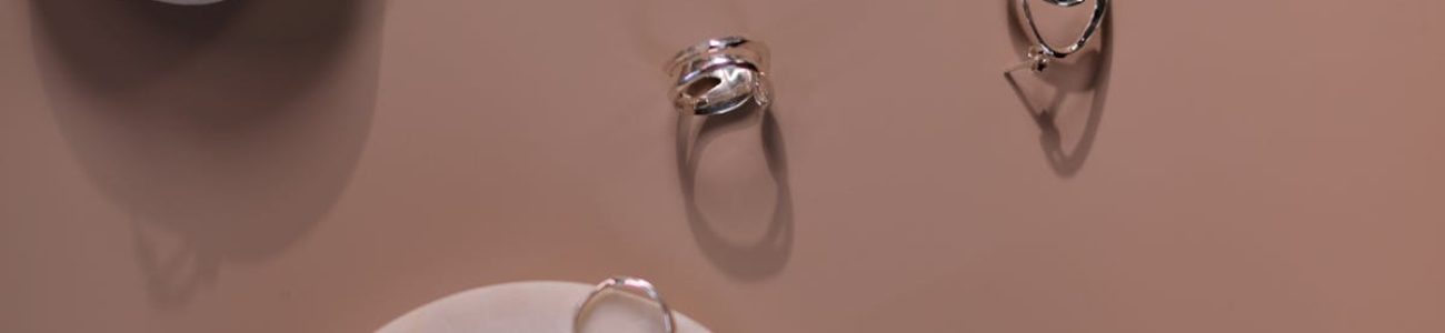 Stylish silver jewelry elegantly arranged on textured stones, ideal for modern accessory showcases.